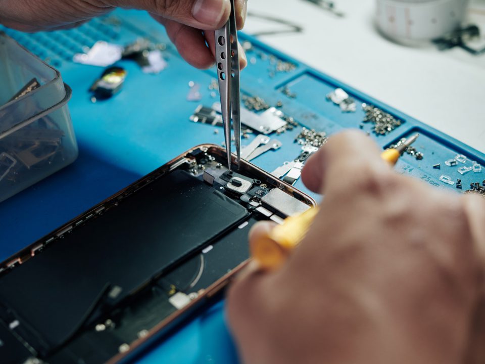 Técnico reparando um iPhone na bancada